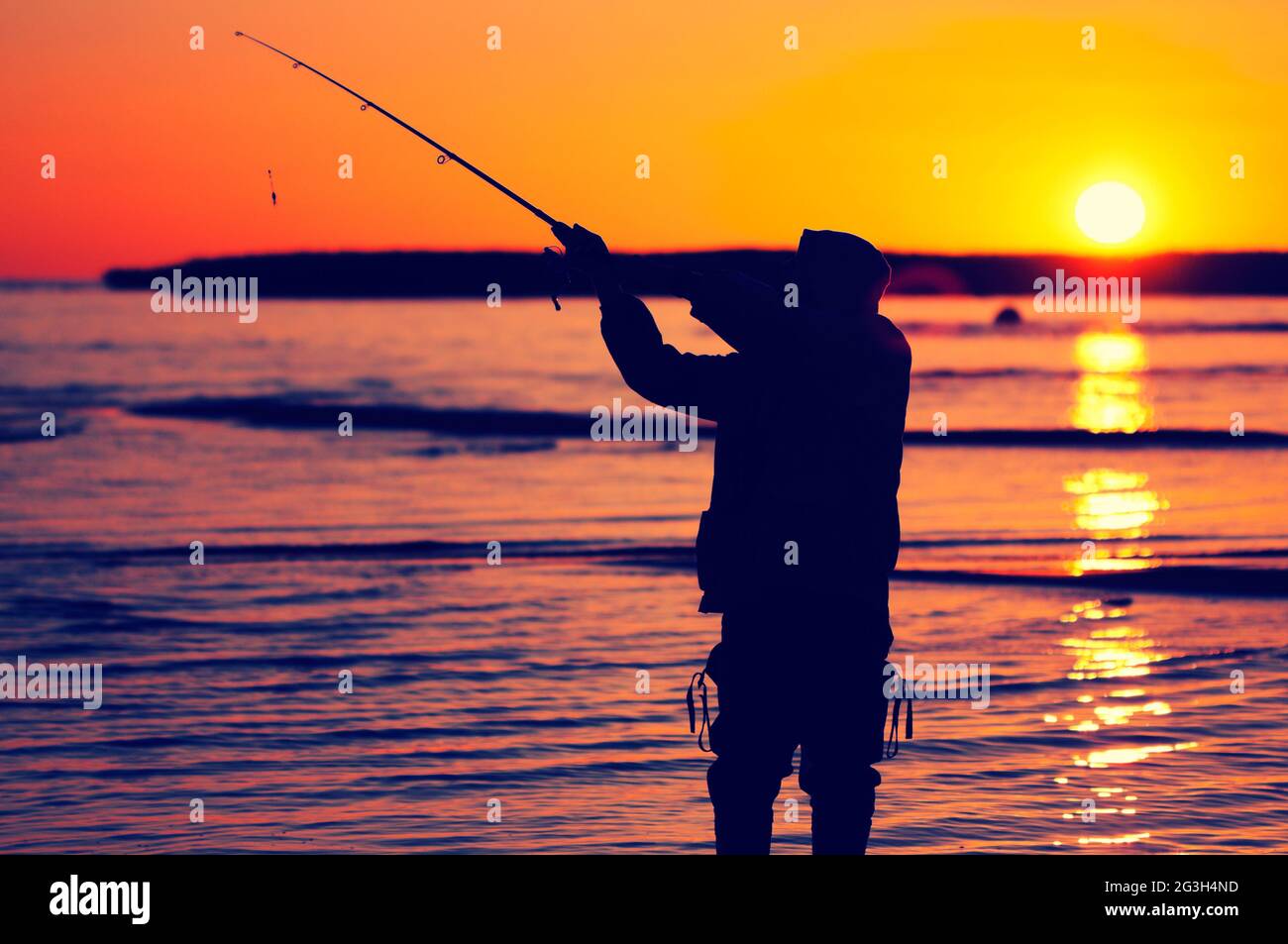 silhouette of a fisherman on the lake at sunset Stock Photo - Alamy
