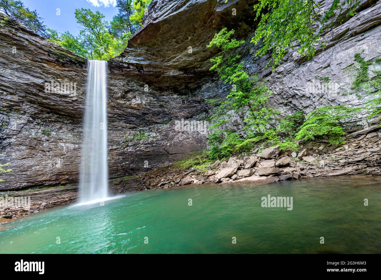 Beautiful Ozone Falls in Cumberland County Tennessee is a scenic swimming hole with a cool, cascading waterfall feeding the pool. Stock Photo