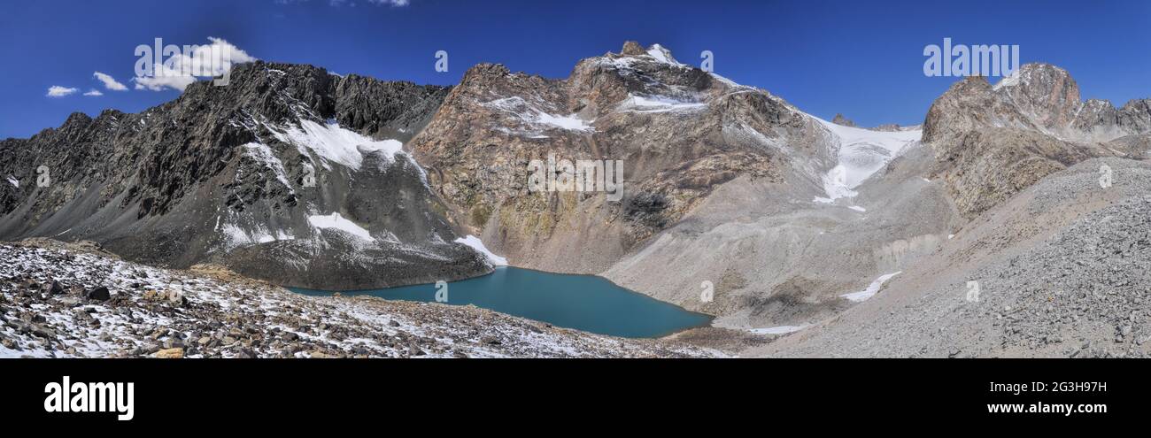 Scenic panorama of lake below highest mountain peaks in Ala Archa national park in Tian Shan mountain range in Kyrgyzstan Stock Photo