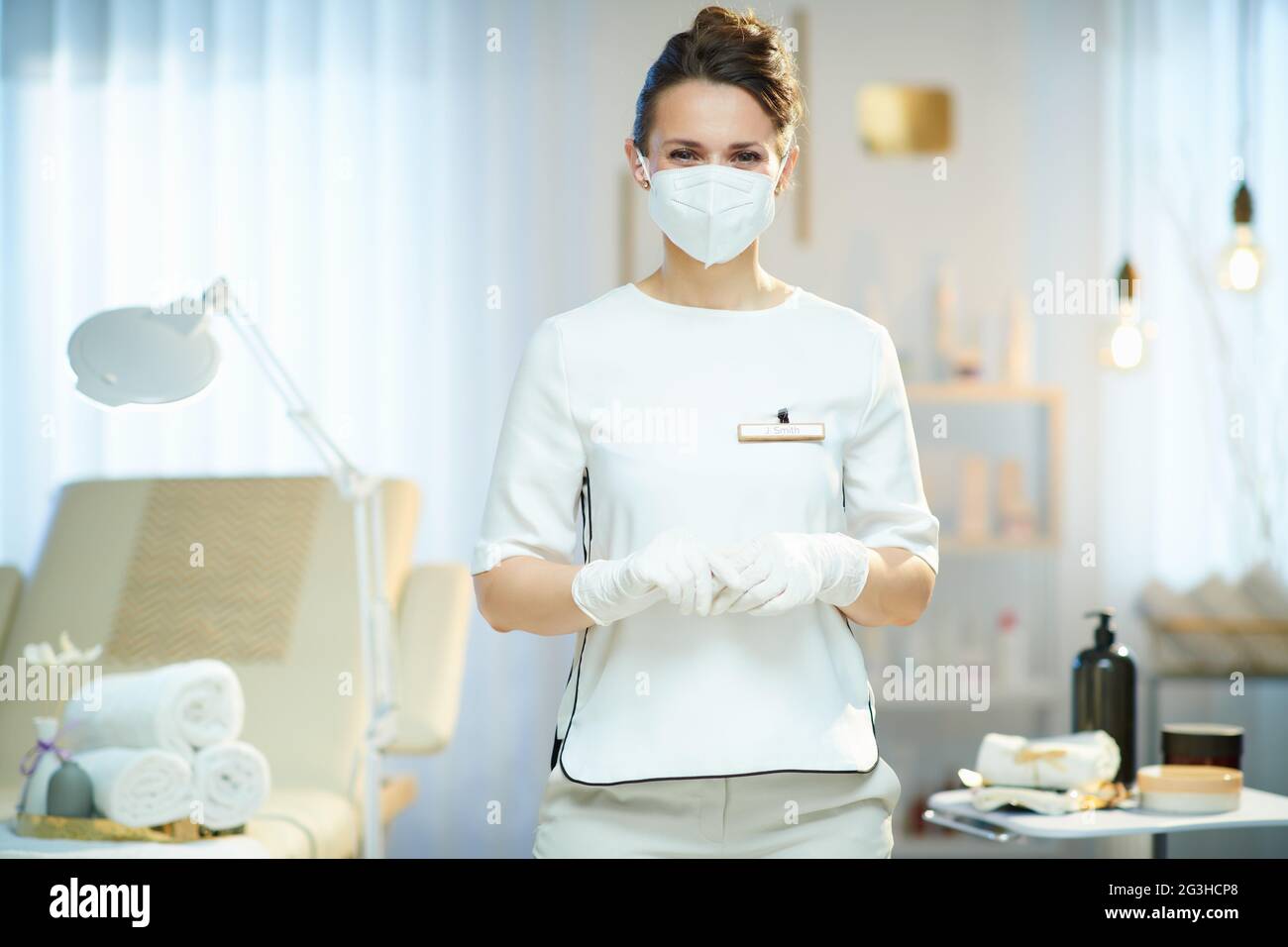 Business during coronavirus pandemic. Portrait of middle aged woman worker with ffp2 mask in modern beauty salon. Stock Photo