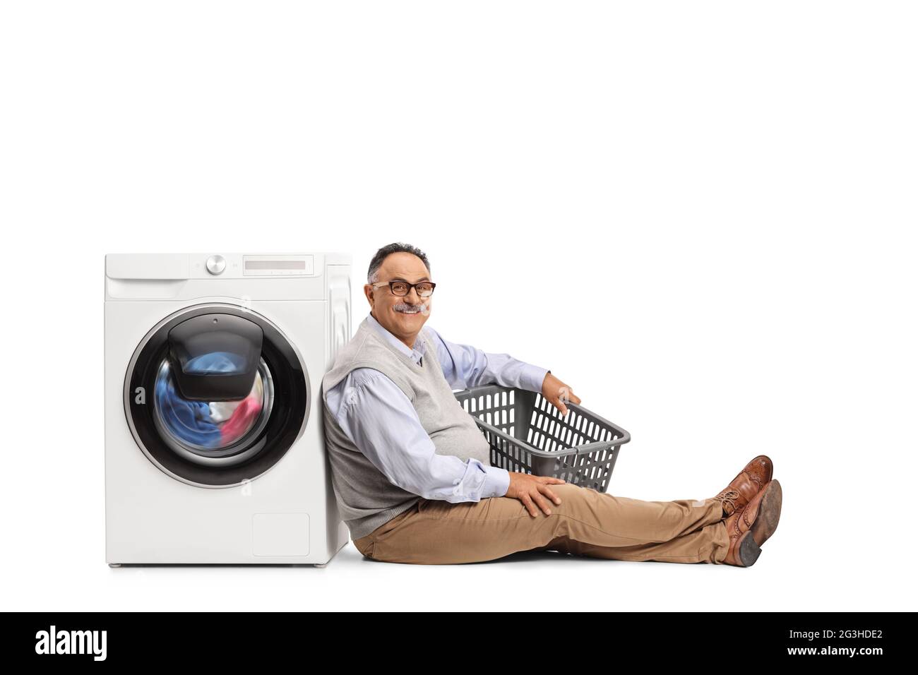 https://c8.alamy.com/comp/2G3HDE2/mature-man-with-an-empty-laundry-basket-sitting-and-leaning-on-a-washing-machine-isolated-on-white-background-2G3HDE2.jpg