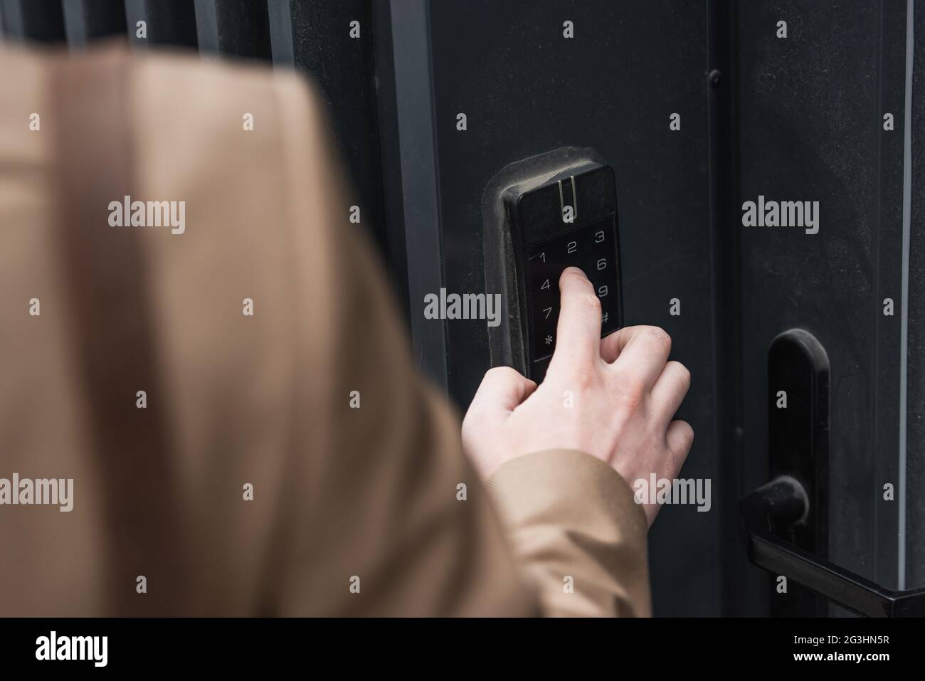 cropped view of man pressing button on intercom keypad Stock Photo