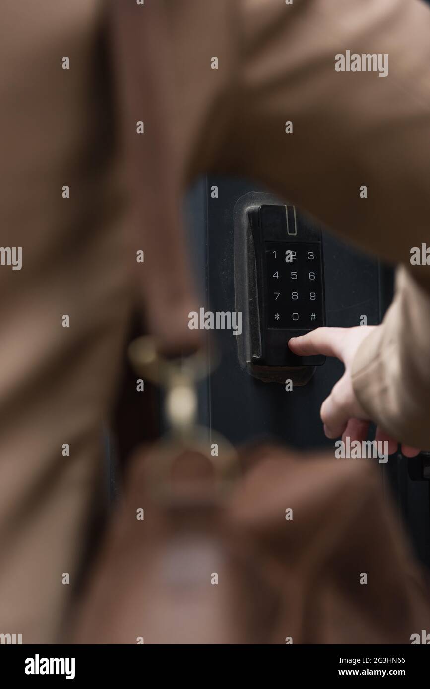 partial view of blurred man pressing button on intercom keypad Stock Photo