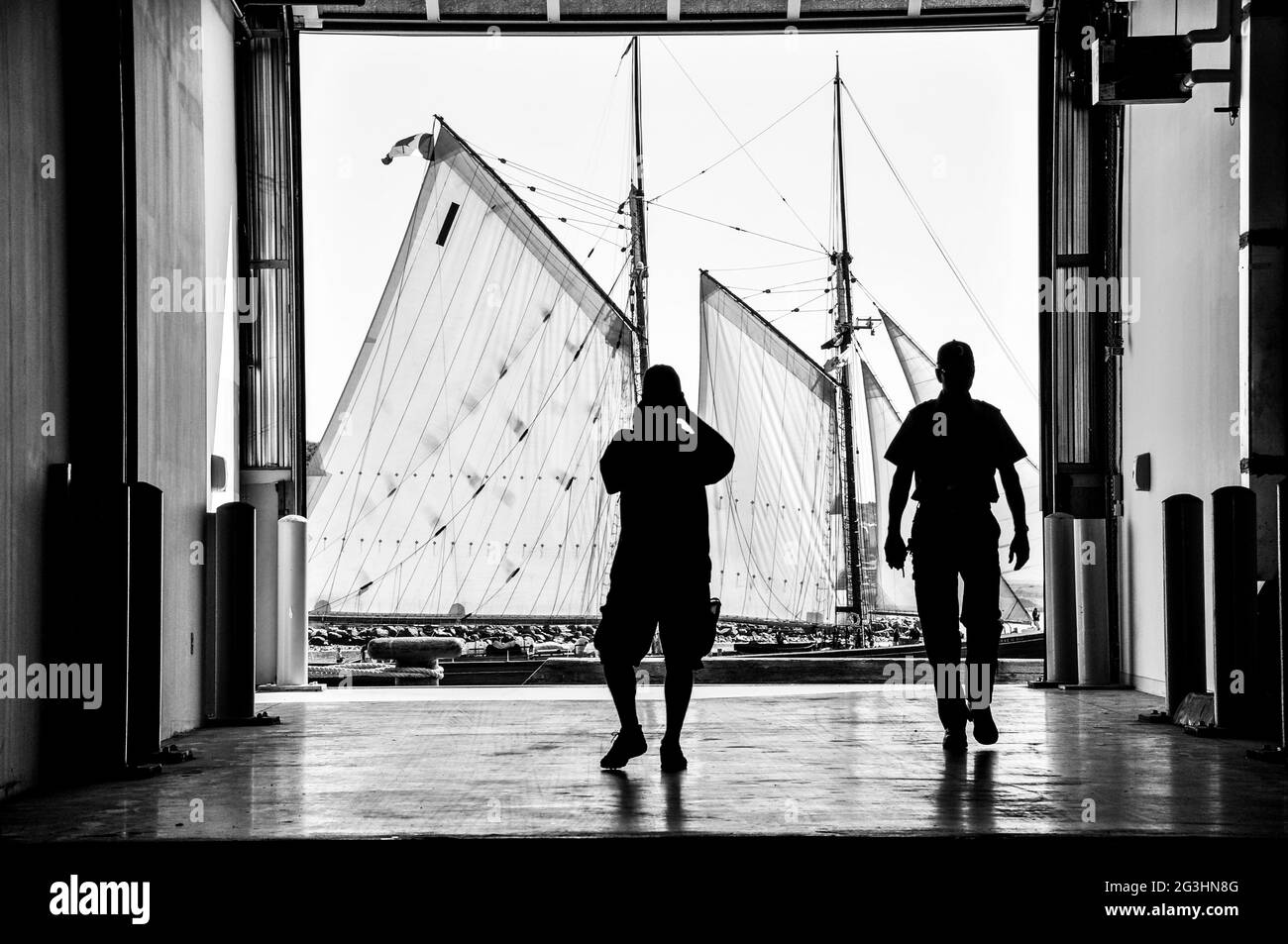 Monochrome image of people watching a tall ship schooner sailing by at the Halifax Tall Ships regatta. Stock Photo