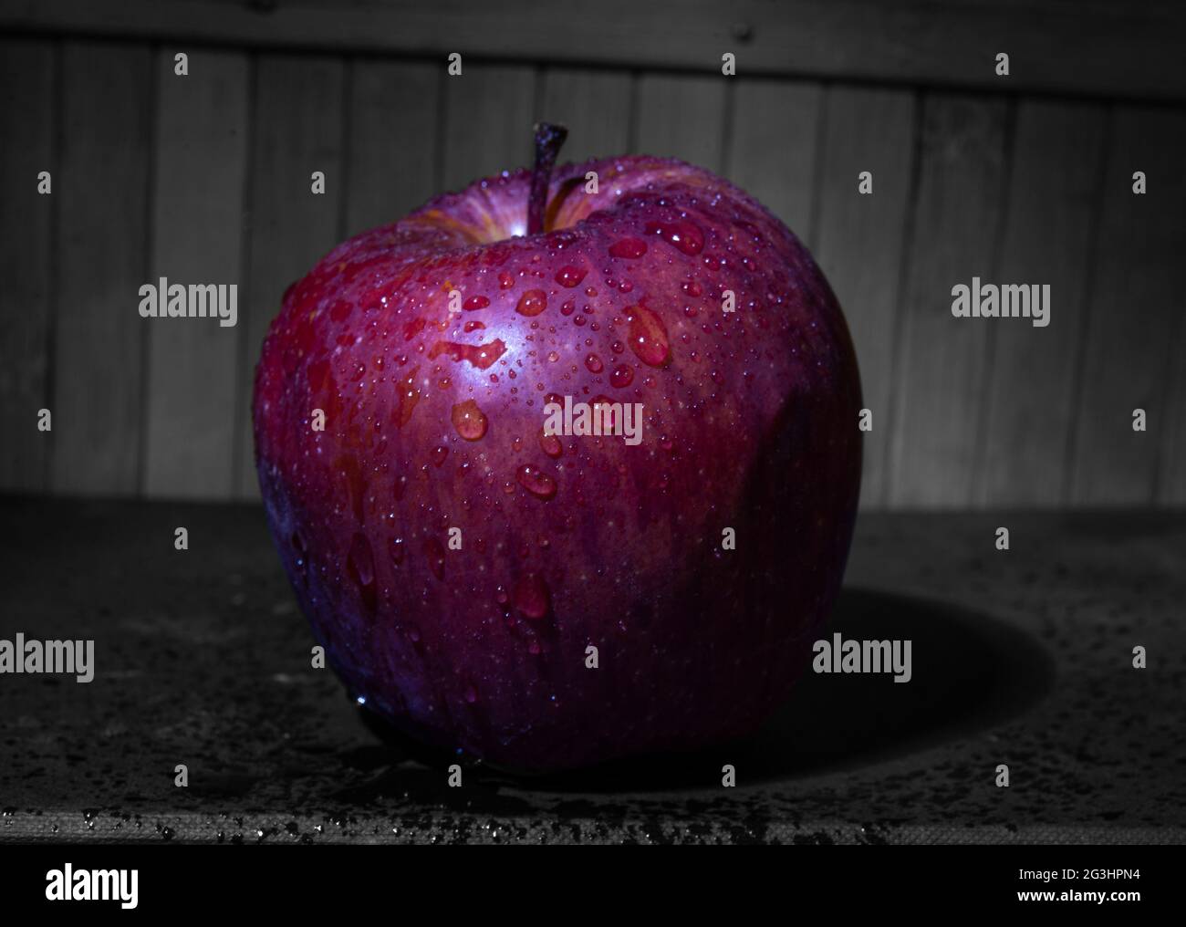 Closeup view of wet Apple with wood background Stock Photo - Alamy