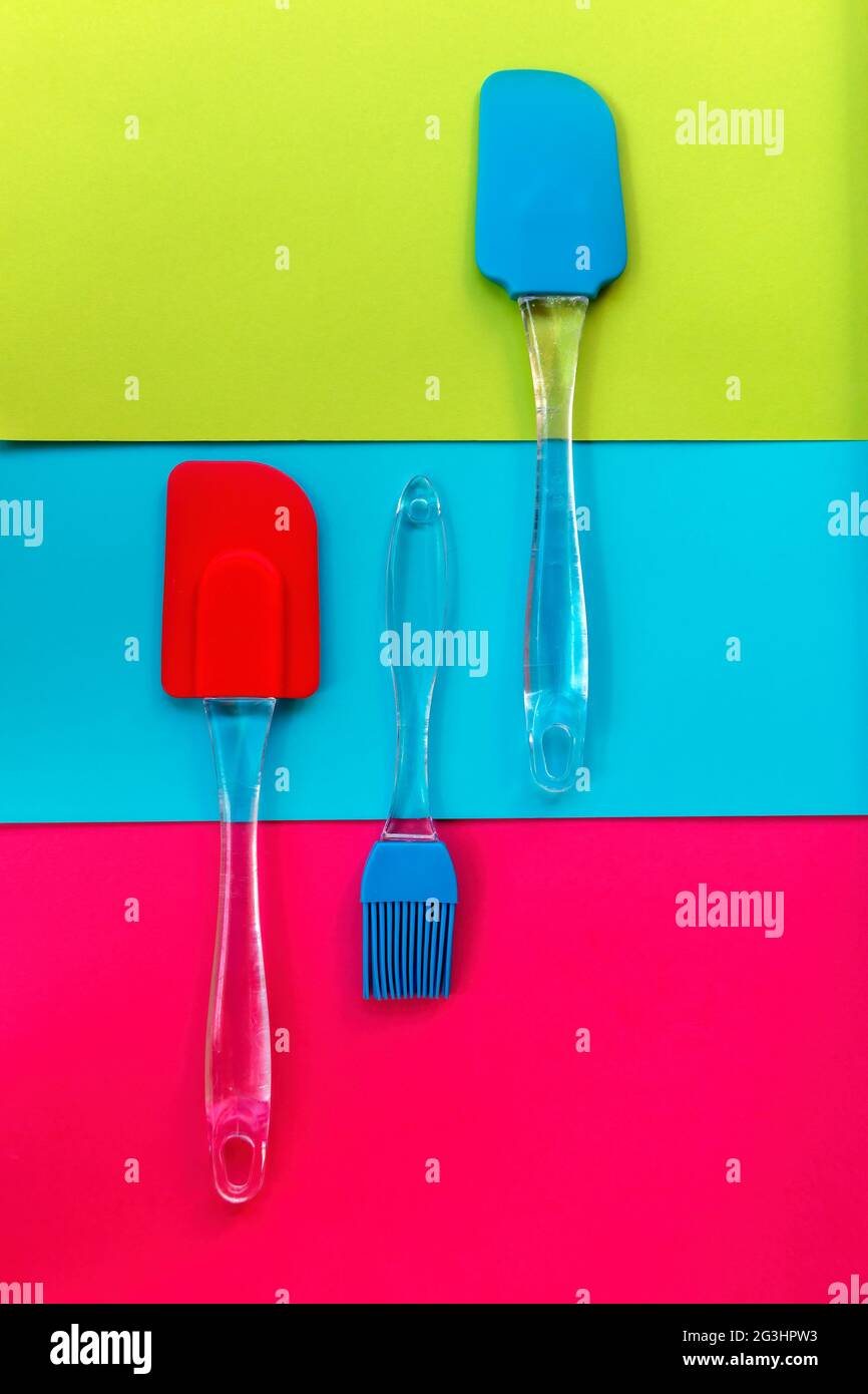 Silicone kitchen utensils on a tricolor background Stock Photo
