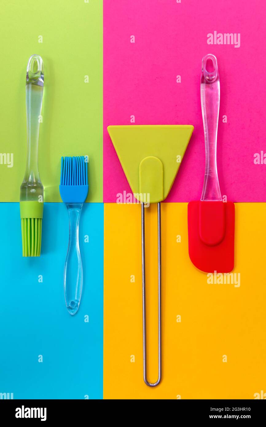 Cooking utensils. Spatulas and silicone brushes on bright colored geometric background Stock Photo
