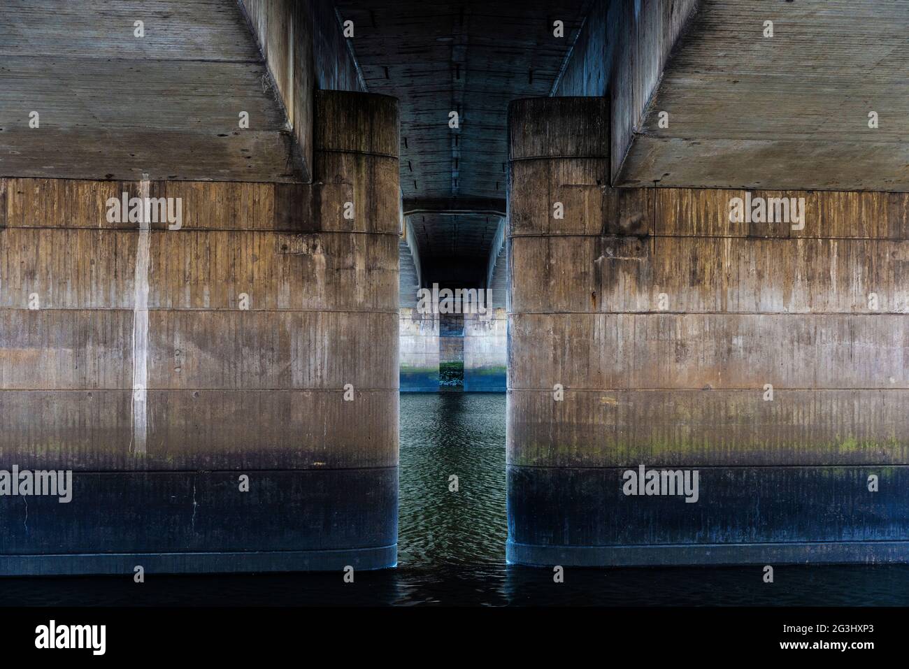 View of the concrete columns from under a bridge as abstract symmetrical background in the Weser River Promenade (Schlachte) in Bremen, Germany Stock Photo