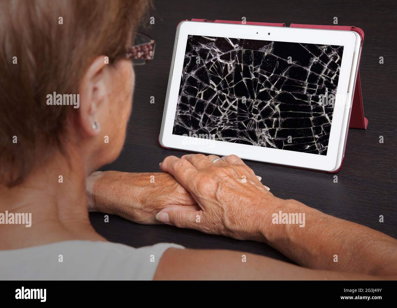 Senior lady with tablet, cracked screen Stock Photo
