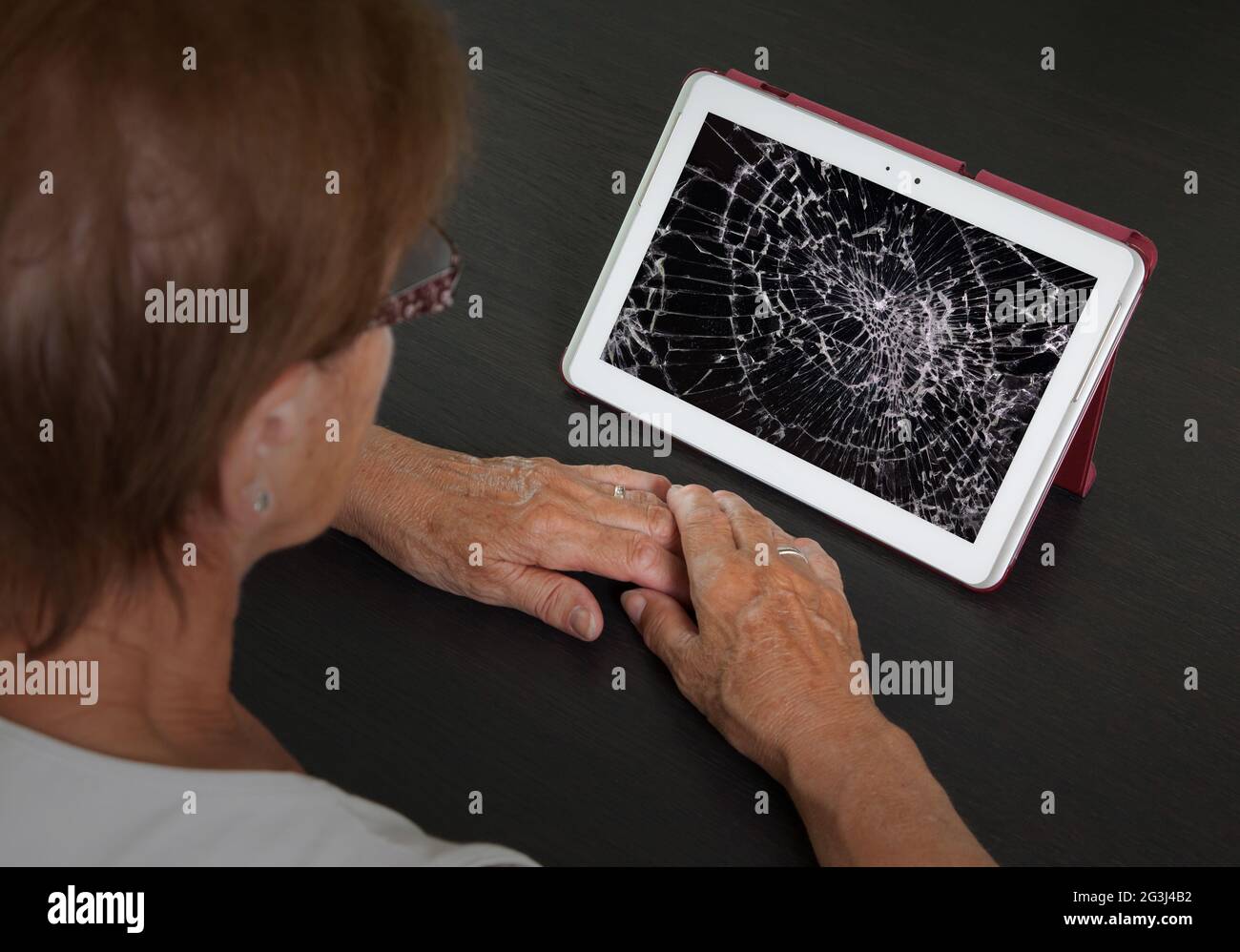 Senior lady with tablet, cracked screen Stock Photo