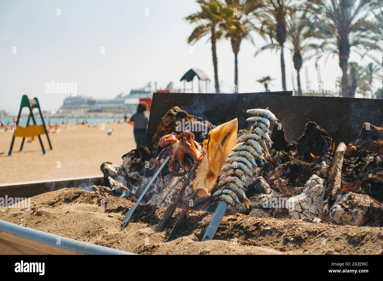 A variety of seafood cooks over a makeshift wood fire barbecue at a restaurant on the Malagueta beach, Málaga, Spain Stock Photo