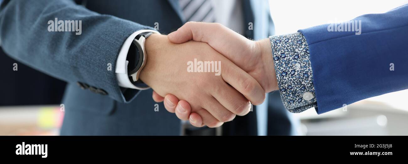 Two businessmen are shaking hands friendly closeup Stock Photo