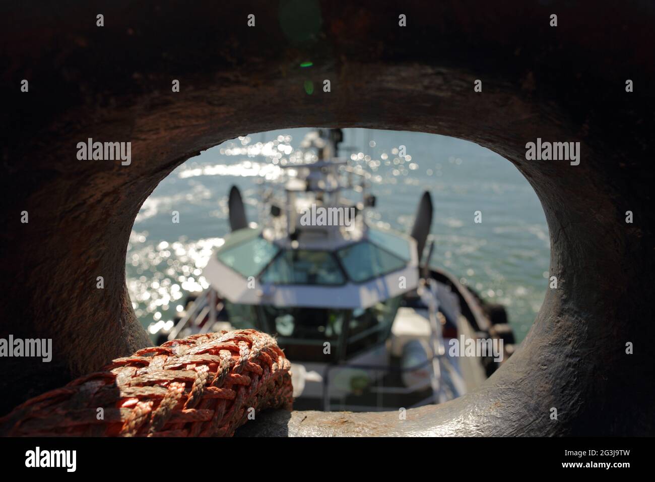 Tugboat will tow ship with strong polyamid Line/ rope for maneuvering Stock Photo