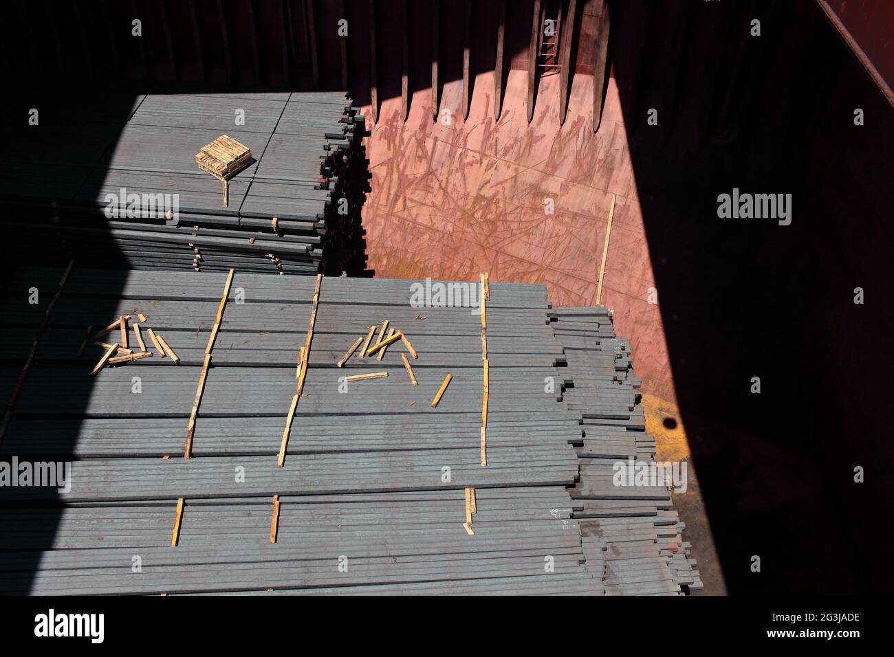 Steel products (profiles, bars)  in the cargo hold. Wooden dunnages are placed to prevent the load from slipping and to provide ventilation Stock Photo