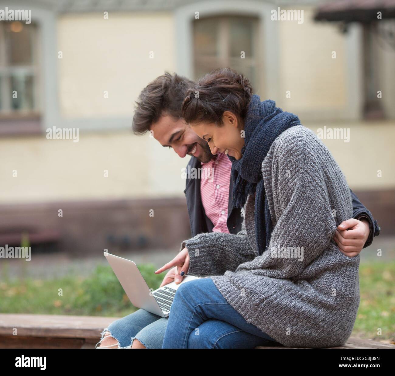 Happy couple surfing the Internet in the city Stock Photo