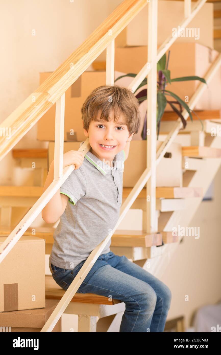 Little boy sitting on stairs indoors Stock Photo - Alamy