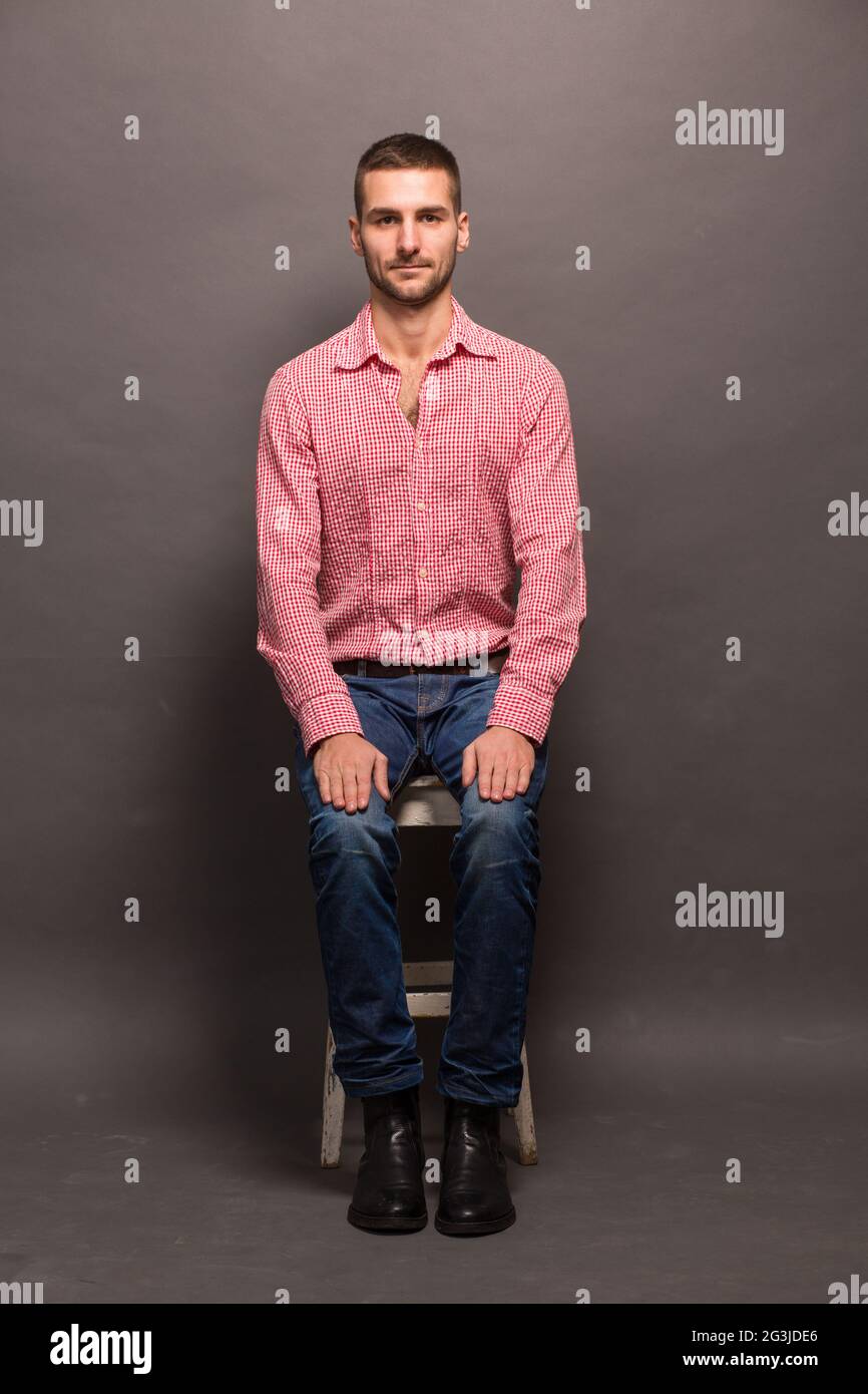 Trendy young man sitting chair hi-res stock photography and images - Alamy