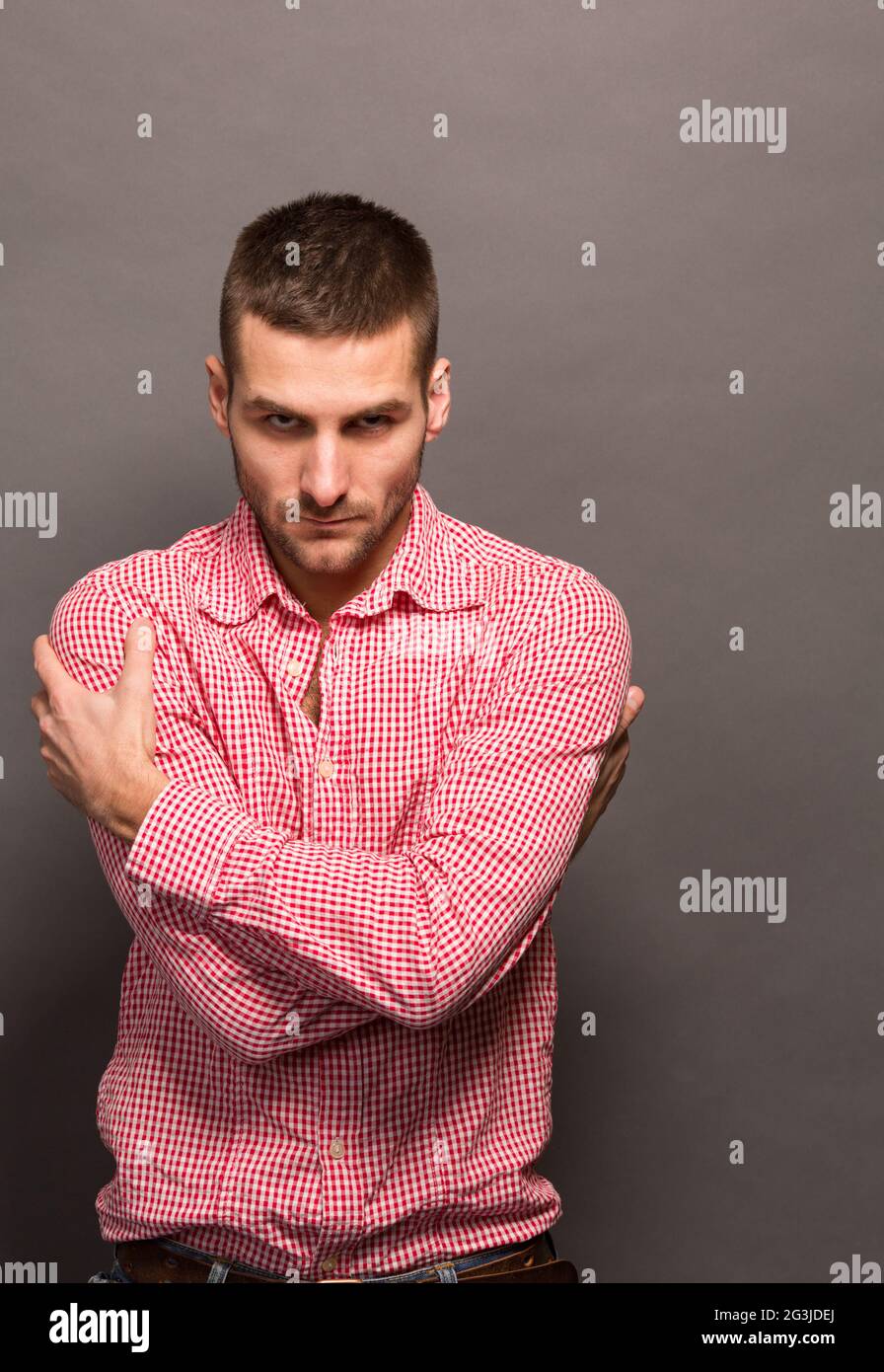 Man hugging himself in studio Stock Photo