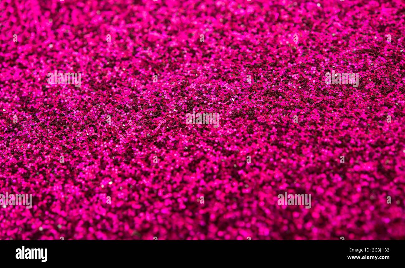Closeup of pink giltter making into a dark background. Stock Photo