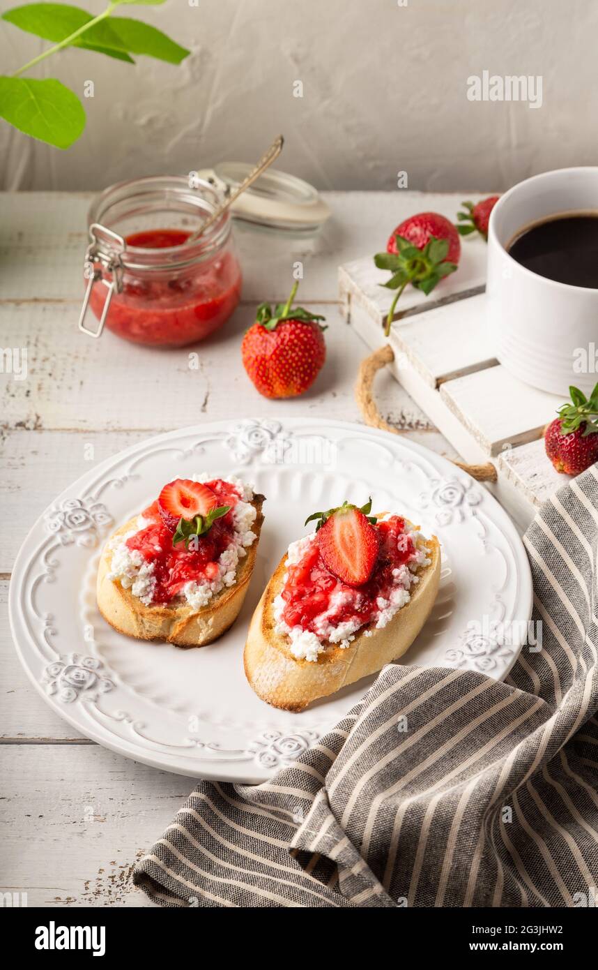 Homemade bruschetta with cottage cheese and strawberries at white