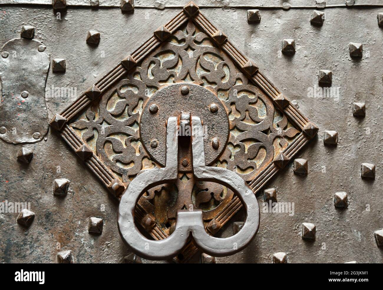 Studded iron door of Palazzo Invrea with a phallic-shaped knocker that invokes the presence in the past of a pleasure house for whealthy clients Stock Photo