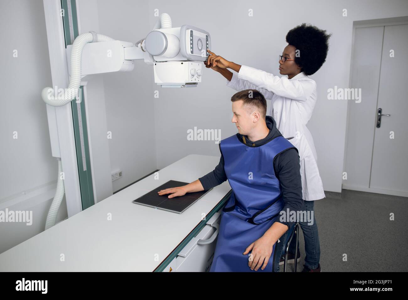 Classic ceilingmounted xray system. Young African woman doctor