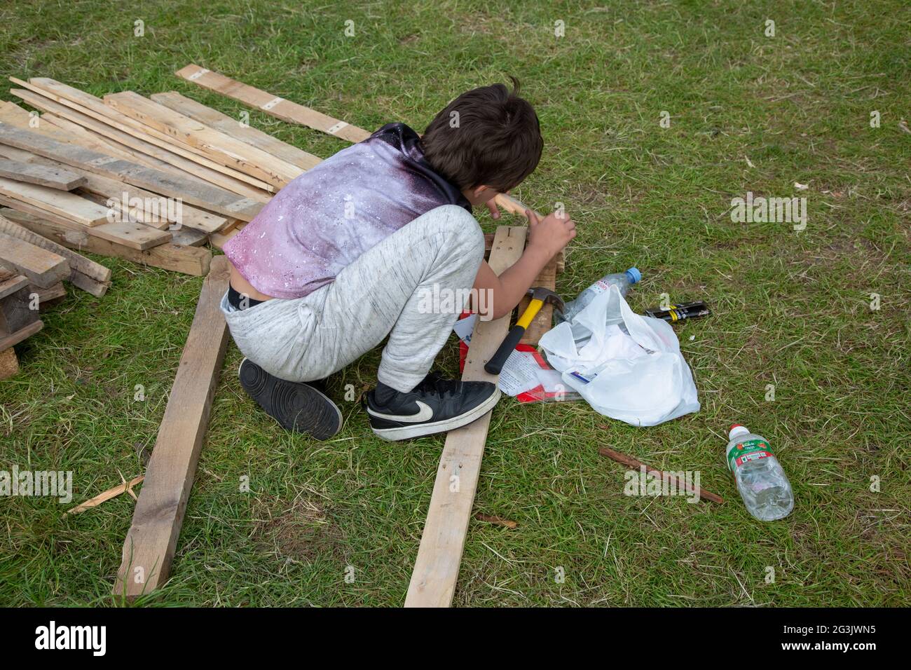 A boy building something on a Freedom protester camp on Shepherd's Bush Green, London, UK. June 2021 Stock Photo