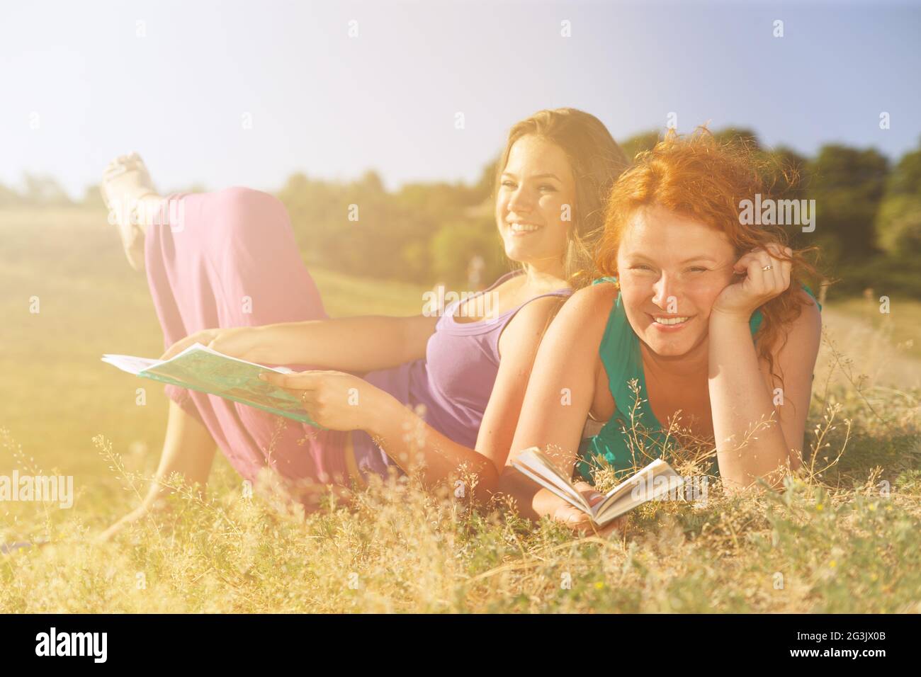 Two women read on grass Stock Photo