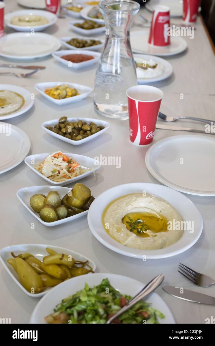 Druze meal with dishes of hummus, peppers, pickles, salad and olives at Alsultan restaurant in Mas'ade, a Druze village in the northern Golan Heights Stock Photo