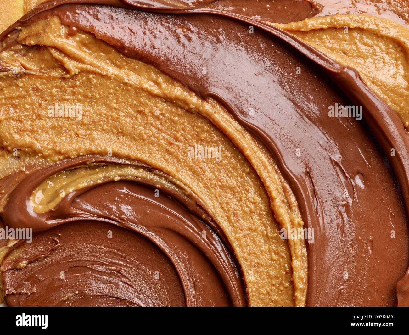 melted chocolate hazelnut cream and peanut butter background, top view