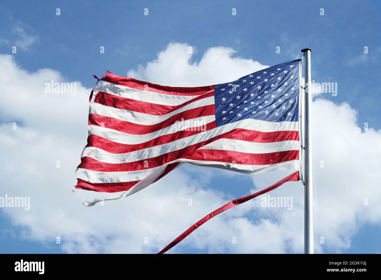 American flag flying against a blue sky Stock Photo
