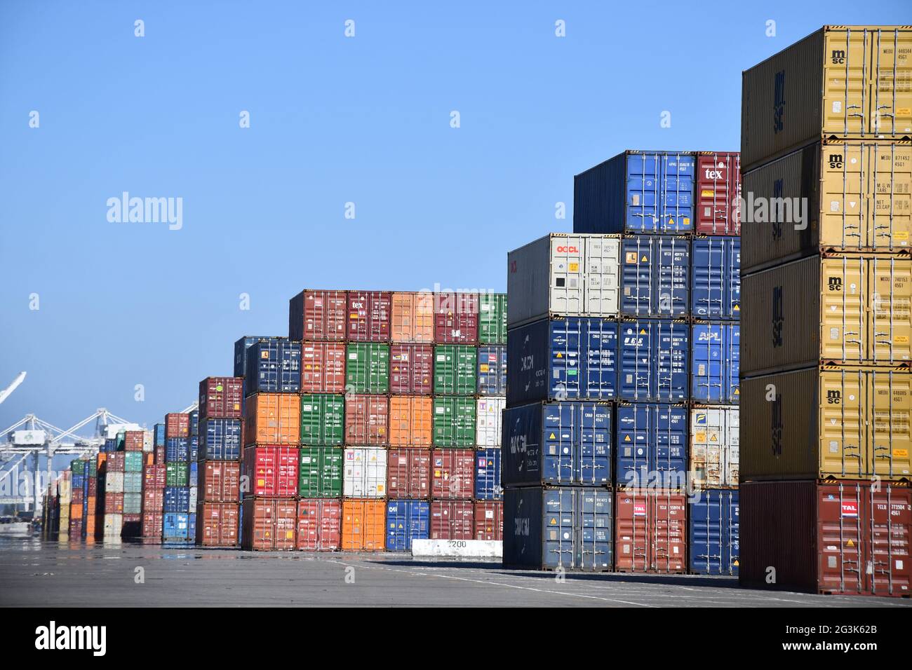 Shipping containers are loaded onto ships at the Port of Oakland, California, one of the busiest global freight ports on the West Coast. Stock Photo