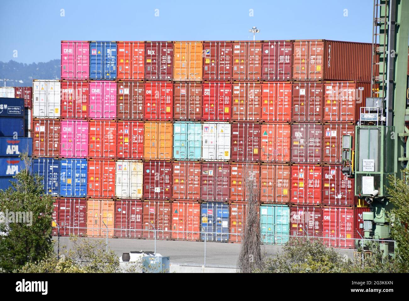 Shipping containers are loaded onto ships at the Port of Oakland, California, one of the busiest global freight ports on the West Coast. Stock Photo