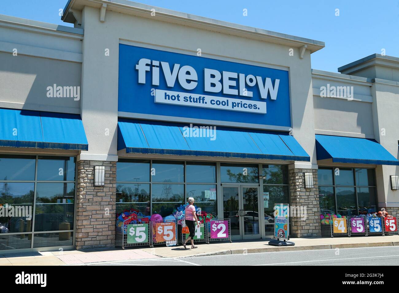 A shopper walks in front a Five Below store at Monroe Marketplace in Pennsylvania. Stock Photo
