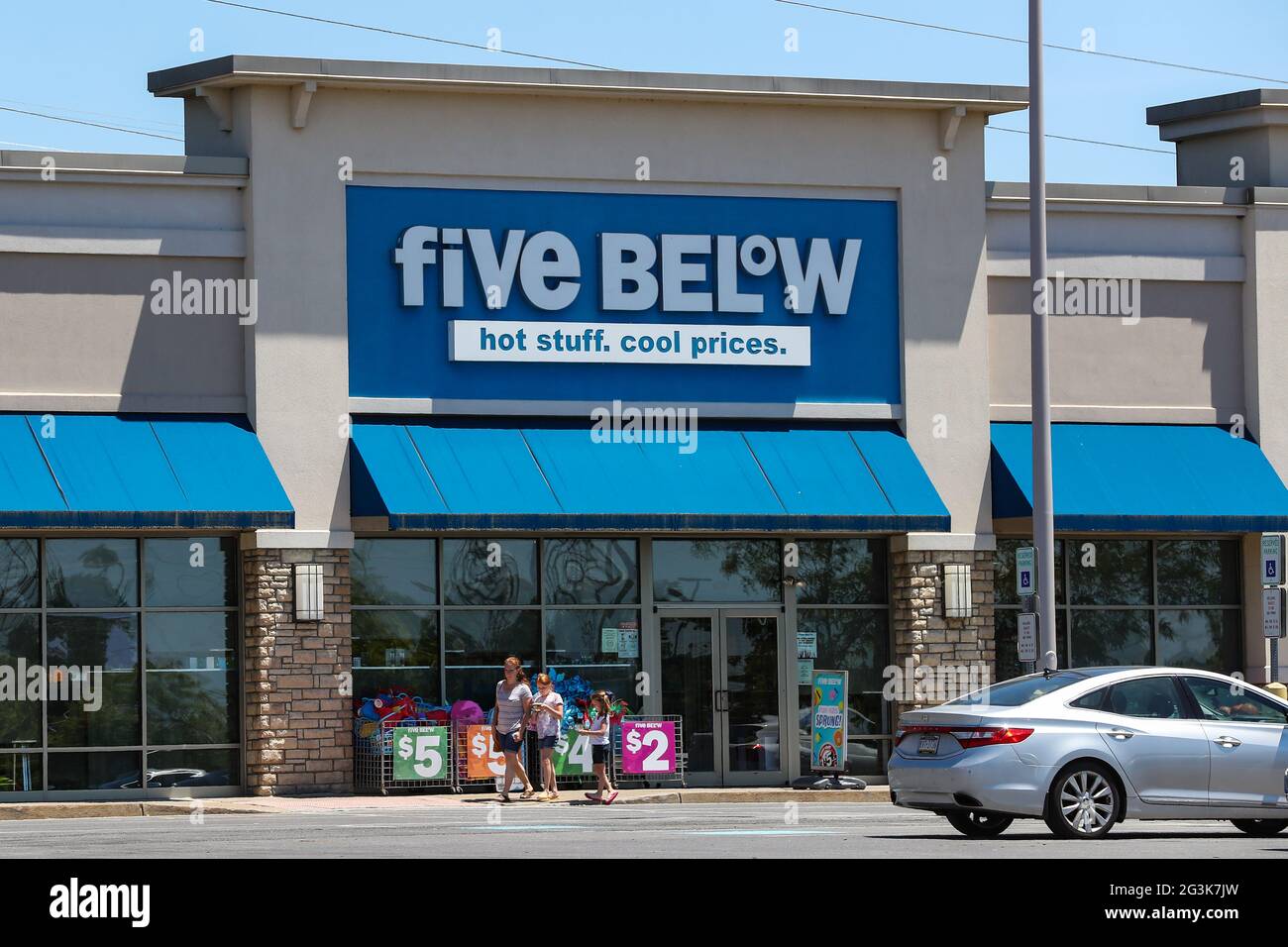 Shoppers walk in front a Five Below store at Monroe Marketplace in Pennsylvania. Stock Photo
