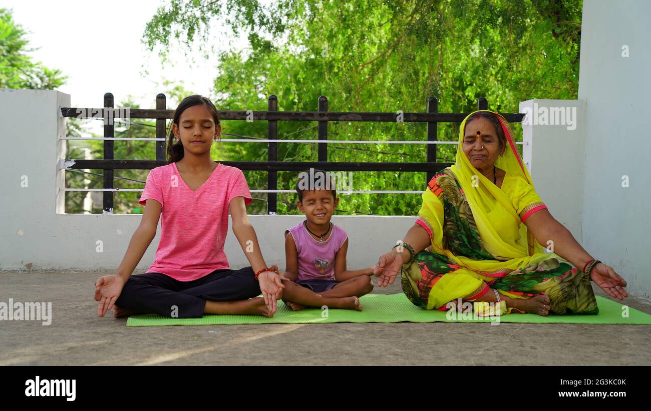 Peaceful people practicing yoga in a group, sitting on a floor with legs closely tucked. Meditation, relaxing, clearing consciousness. Eyes closed, ha Stock Photo