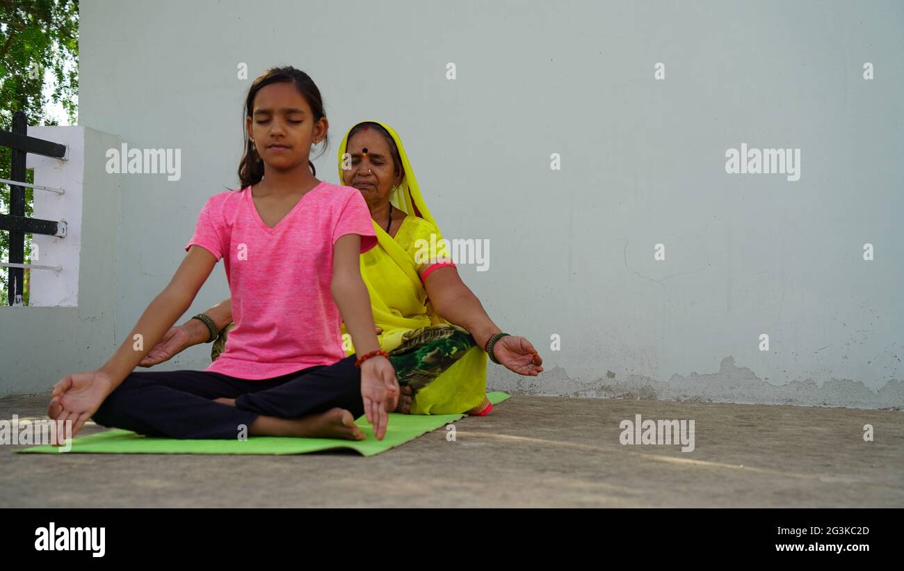 Peaceful people practicing yoga in a group, sitting on a floor with legs closely tucked. Meditation, relaxing, clearing consciousness. Eyes closed, ha Stock Photo