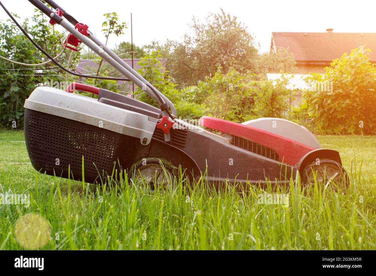Cutting Grass A lawn mower on a lush green. Gardening and landscaping concept. Stock Photo