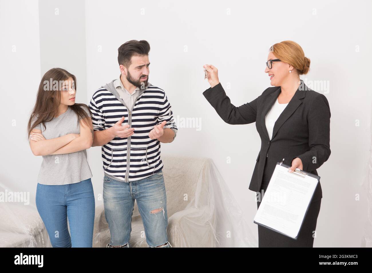 Realtor proposing to sign a cotract to man and woman. wha are not agree. Stock Photo