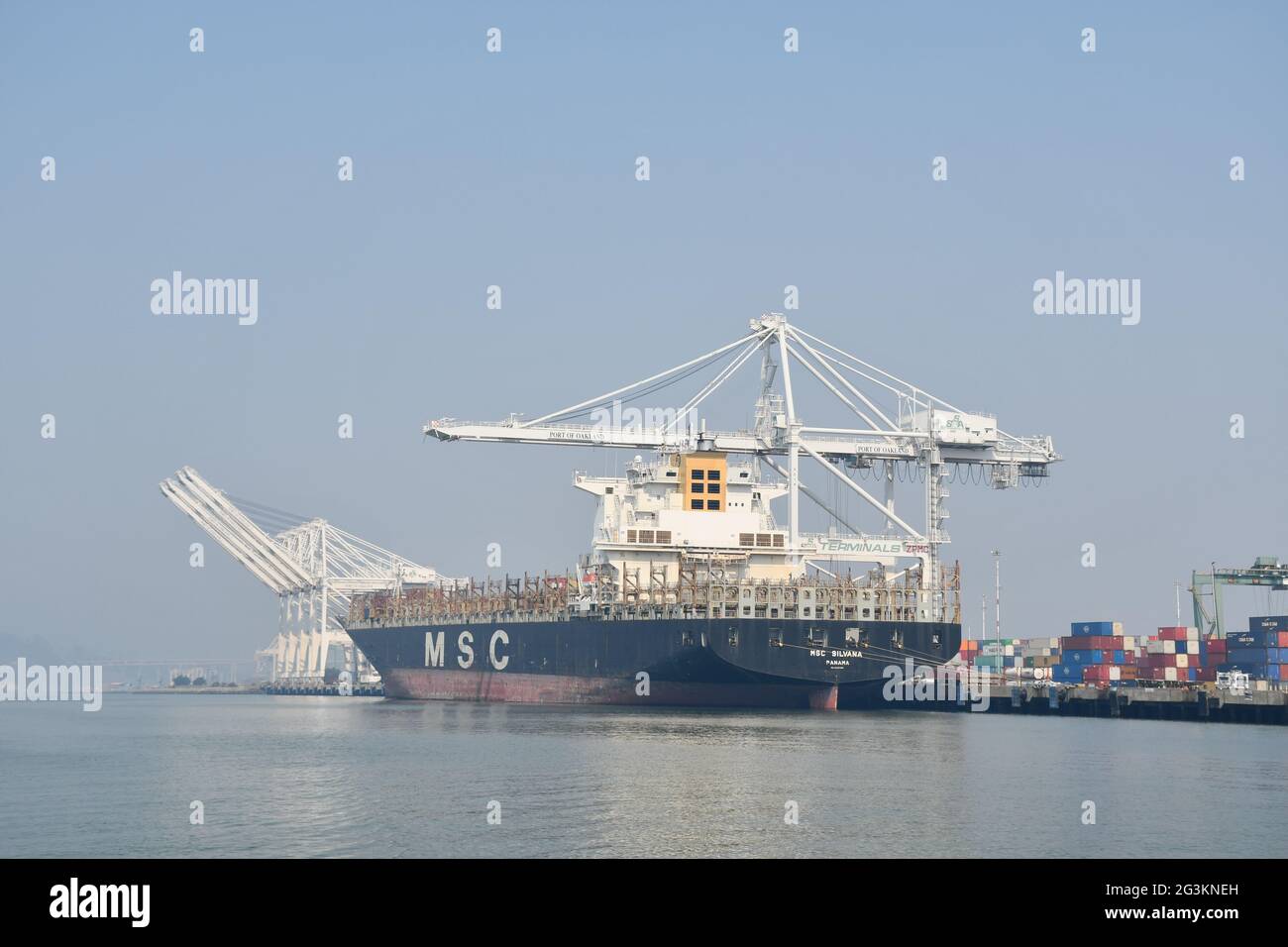 Container ships being loaded at Port of Oakland, California. Sky is obscured because of smoke from forest fires. Stock Photo
