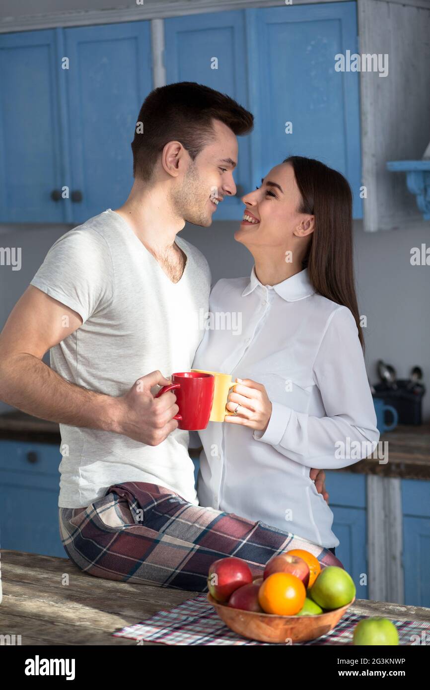 Smiling couple at kitchen looking eyes to eyes. Stock Photo