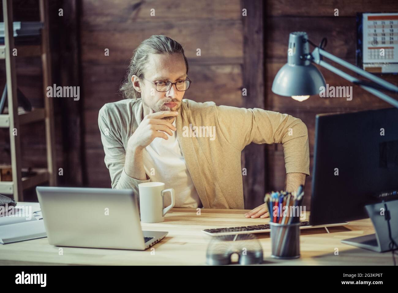 Freelancer thoughtfully looking in computer. Stock Photo