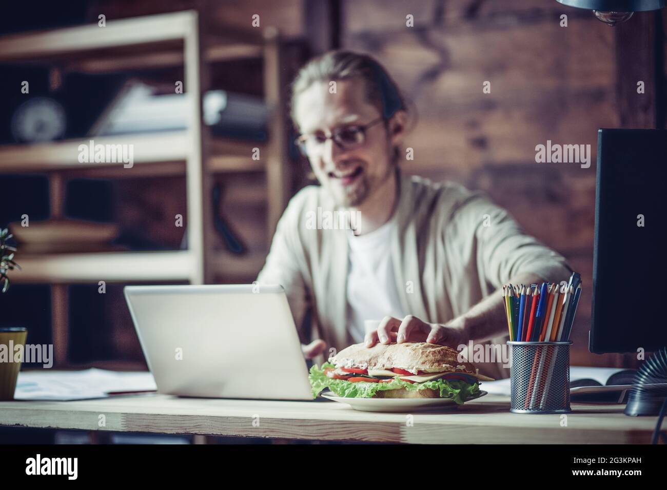 Man working at home going to eat at working place. Stock Photo