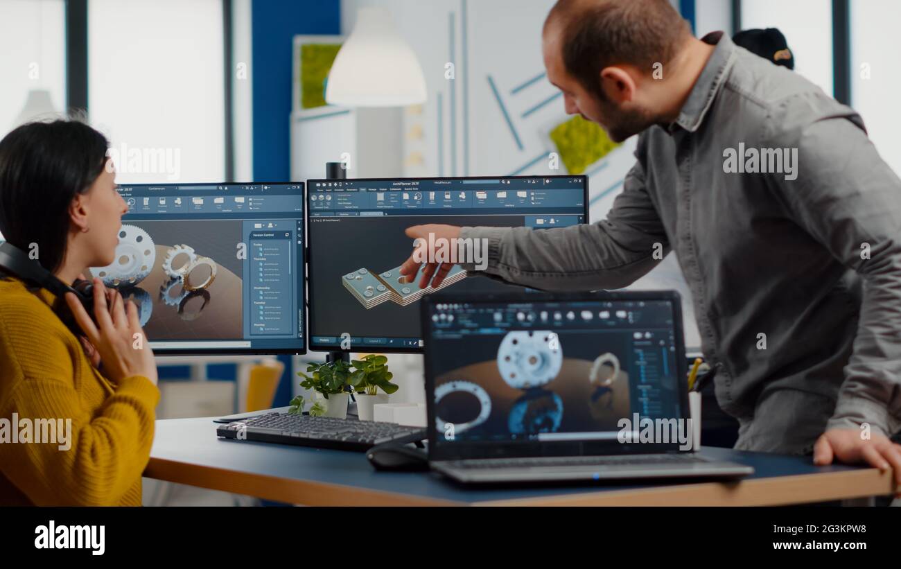 Industrial development engineer analysing and sharing ideas with project manager working on computer. Team of professionals using CAD Software for modern industrial engineering design. Stock Photo