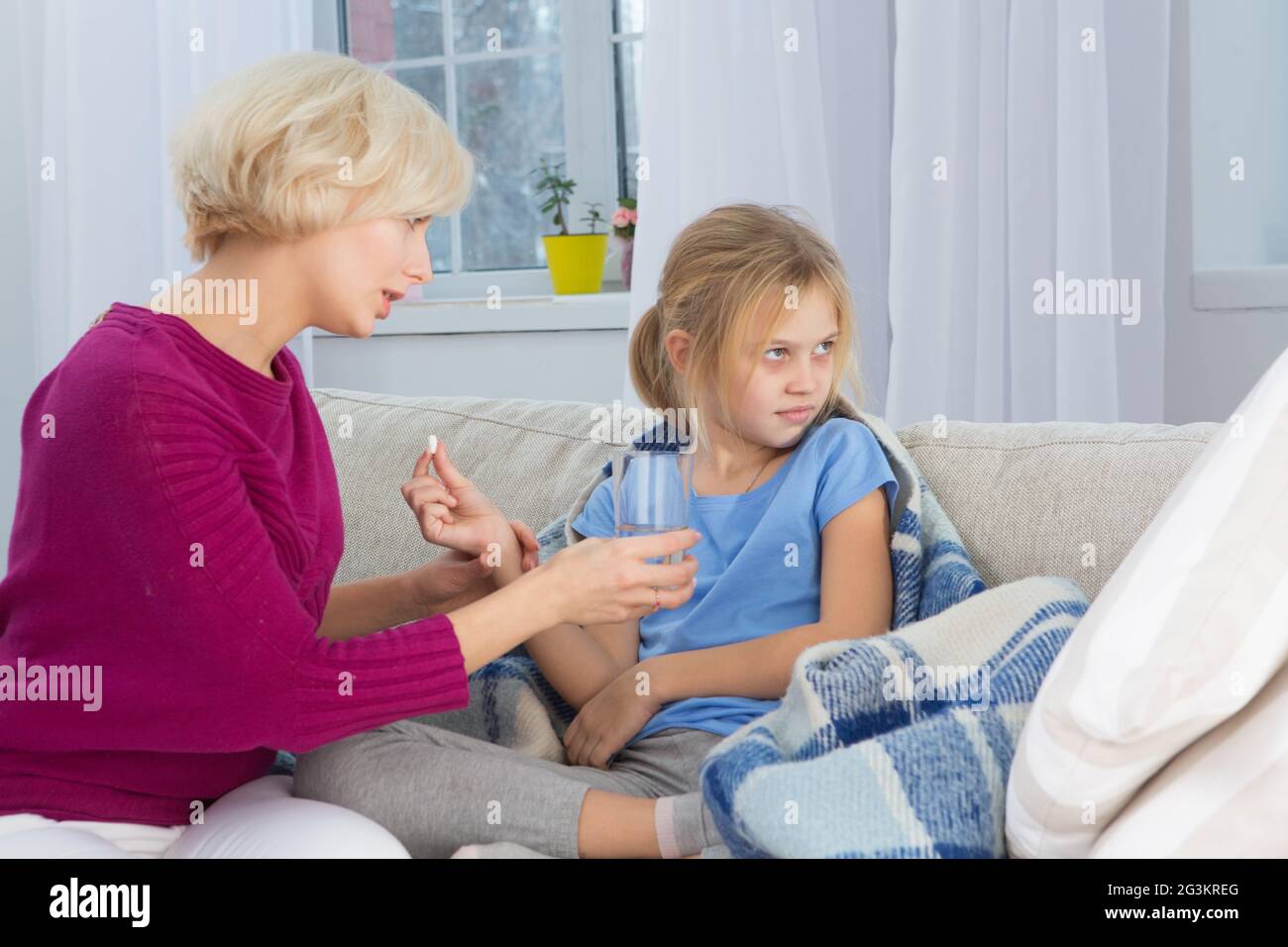 Mom giving medicines to her sick child. Stock Photo