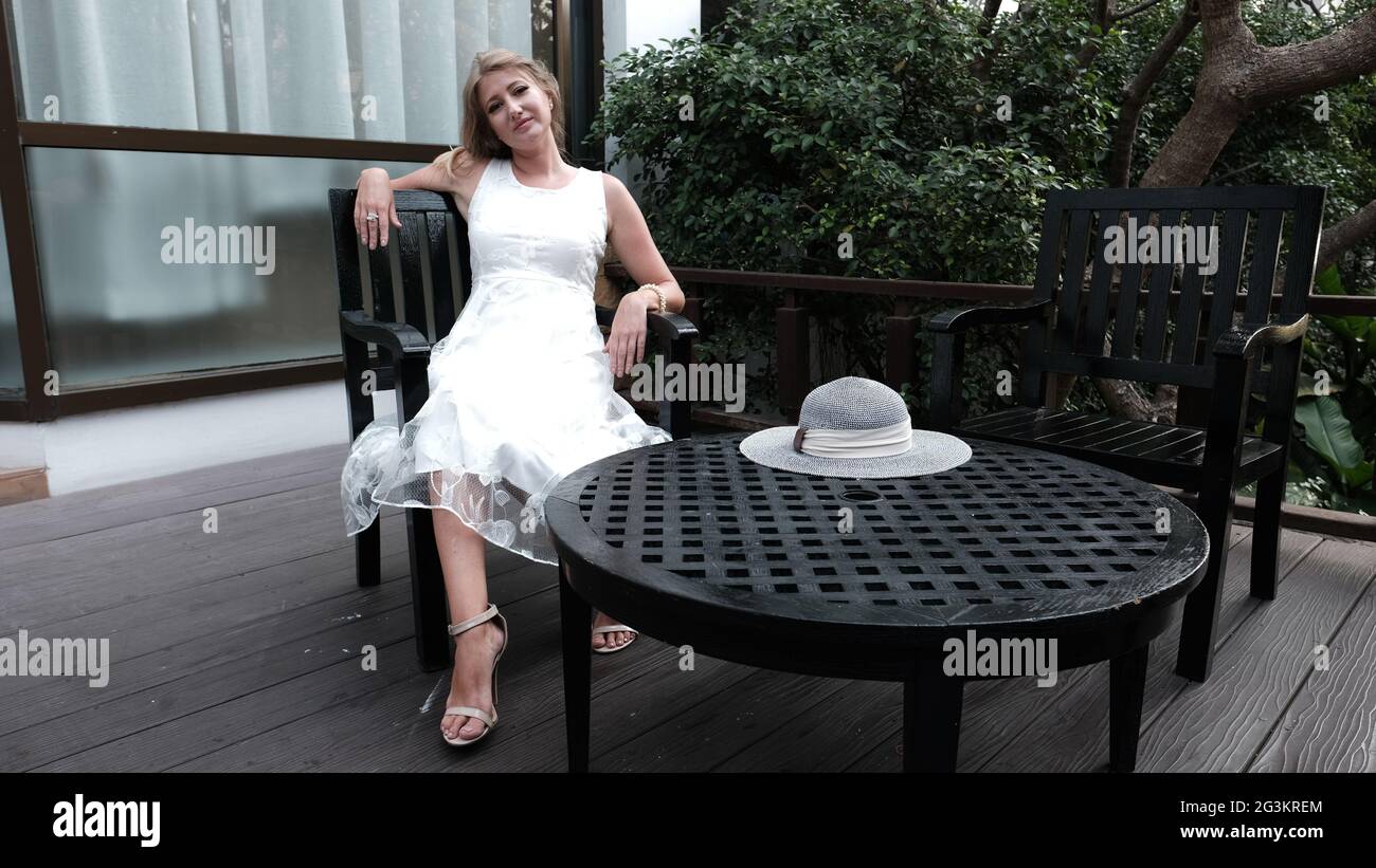 Eastern European Caucasian woman middle aged blonde hair light skin pale complexion in white dress outside summer time casual Stock Photo