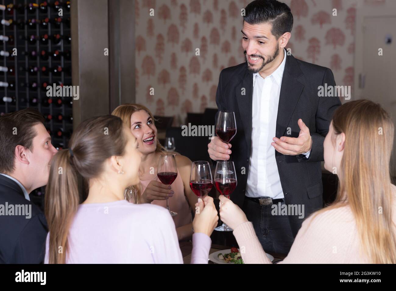 Handsome man pronouncing toast in restaurant Stock Photo