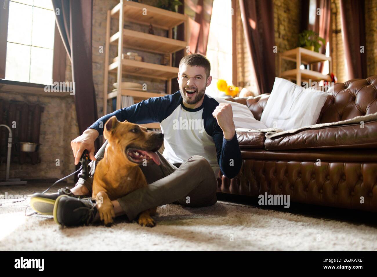 Happy man with his dog at home. Stock Photo