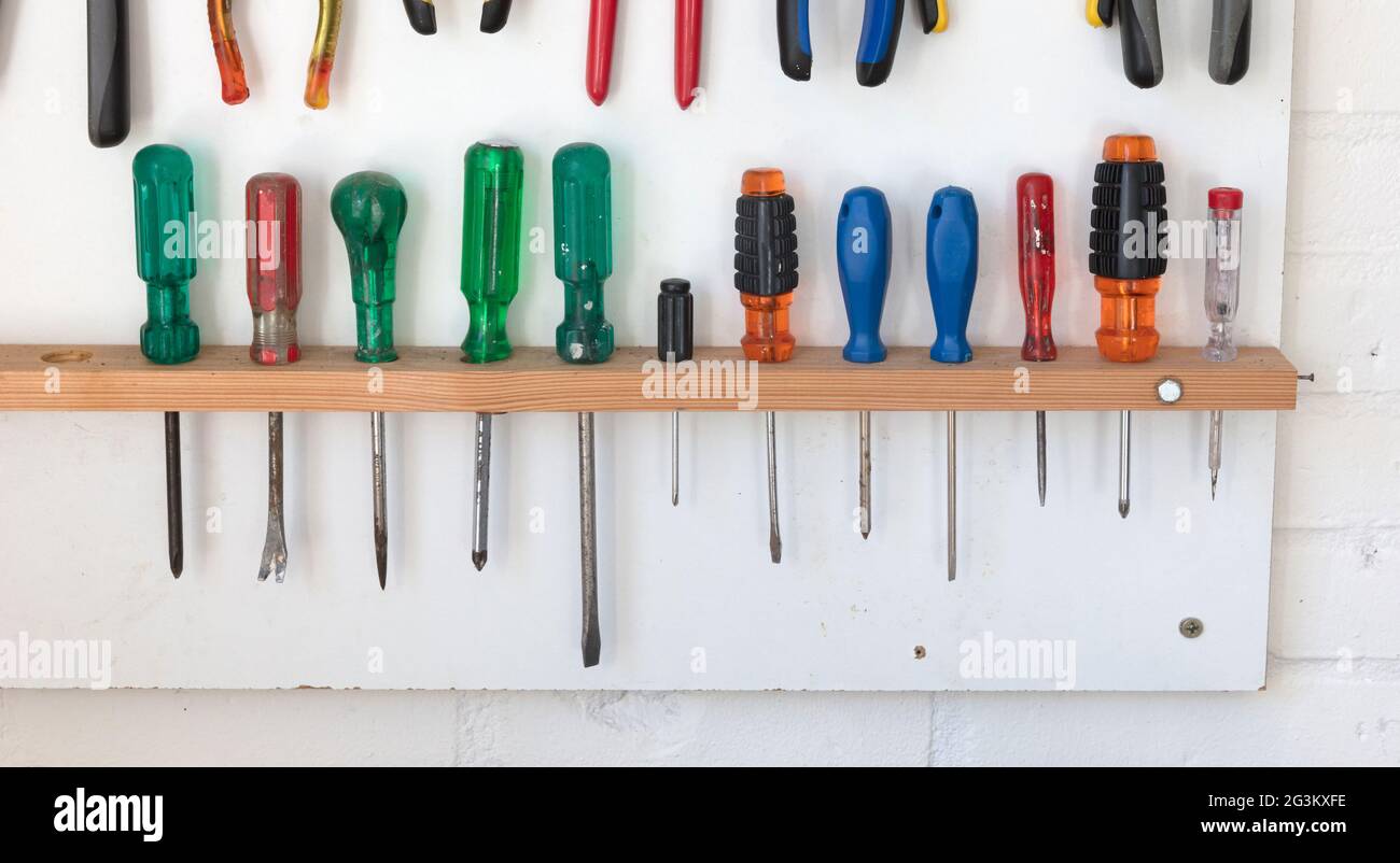 Assorted tools on a white tool board Stock Photo