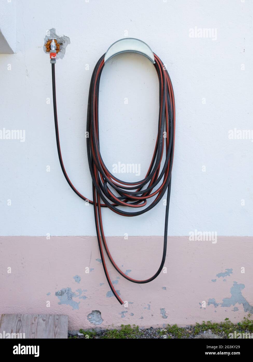 Garden hose hanging on a wall Stock Photo Alamy
